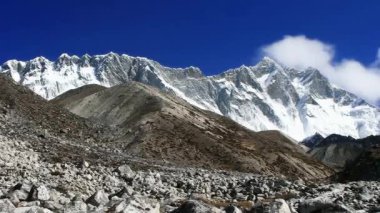 Kayalık Himalayalar karla kaplıydı. Dağların üzerindeki hızlı bulutların hızlandırılmış videosu 