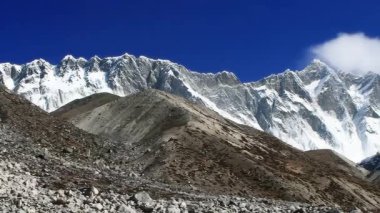Kayalık Himalayalar karla kaplıydı. Dağların üzerindeki hızlı bulutların hızlandırılmış videosu 