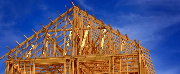 用木梁框架和天空建造新住宅或归还建筑物的建筑工人 — 图库照片