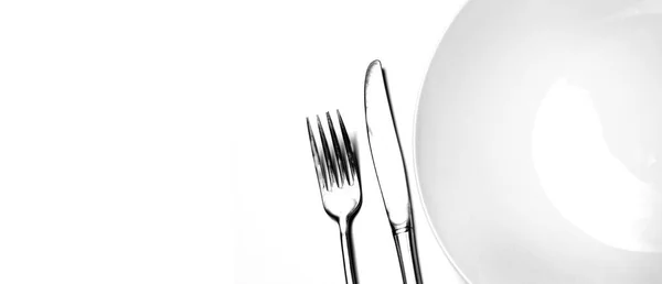 ナイフとエレガントな食事と空想的な食べ物のための白い背景に白いプレートと銀食器をフォーク — ストック写真