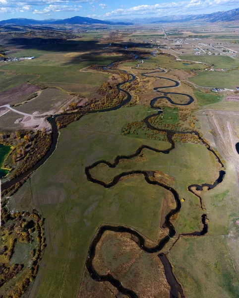 草地フィールド内のウォータークリーク川や水路の空中ドローンビュー — ストック写真