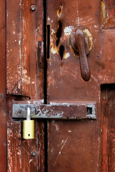 Old rusty handle on door with lock for security