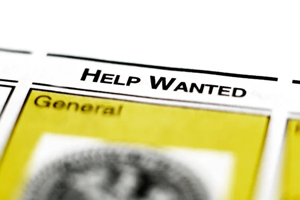 Closeup of newspaper clipping for help wanted advertisement for employmenbt and labor jobs
