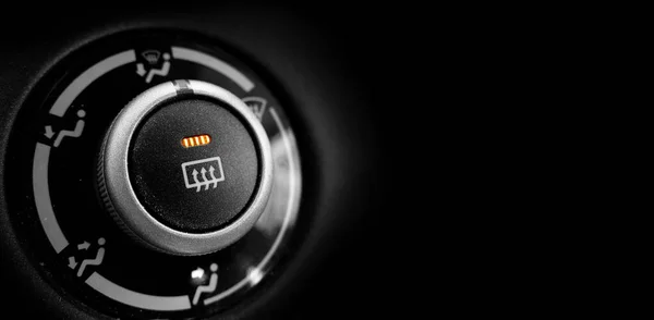車の中で霜ボタンは オレンジ色の光輝く黒の背景でオンになりました — ストック写真