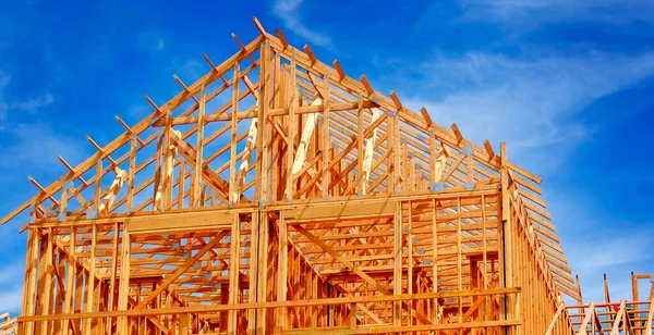 用木梁框架和天空建造新住宅或归还建筑物的建筑工人 — 图库照片