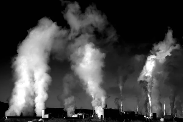 工場の煙突は大気中の汚染物質を上昇させる煙に汚染を噴出しました — ストック写真