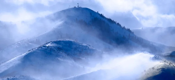 冬の暴風雪の中で雪を吹いて山は強風をスクワール — ストック写真