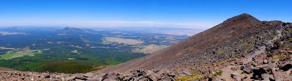 全景图像 一个人在荒原上爬上山顶 山下有绿谷 — 图库照片