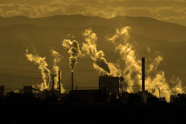 Factory creating pollution and smoke into the air from a smokestack pollute