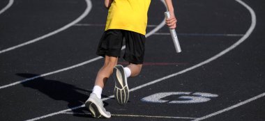 Sarı tişörtlü bir koşucu bayrak yarışına hazır.