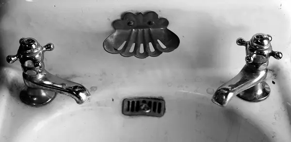 老式古式古式浴室洗涤槽和热水及冷水水龙头 免版税图库照片