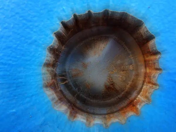 stock image Closeup of old rusty bottle cap bottlecap on blue background texture