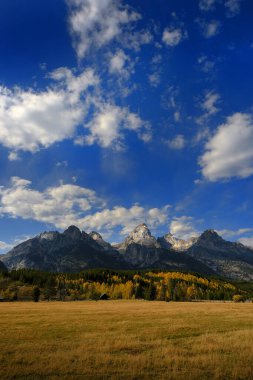Grand Teton dağlarının ayrıntıları, sonbaharda Wyoming 'deki Tetons sıradağları mavi gökyüzü ve dramatik bulutlarla sonbahar manzarası.
