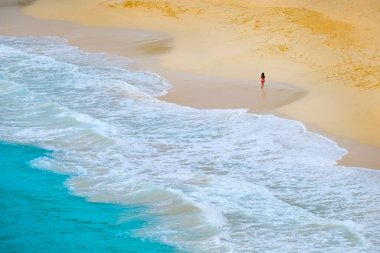 Okyanus dalgaları ve kız yürüyüş yuvarlanan Bautiful beach