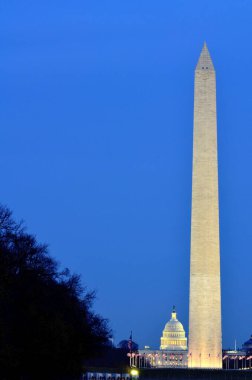 Amerika Birleşik Devletleri Washington Anıtı Capitol 'ün arka planında geceleyin parlayan