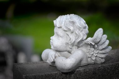 Mezar taşındaki kanatlı melek melek heykelinin ayrıntıları. Mezar taşındaki çocuk yüzü.
