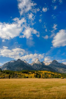 Grand Teton dağlarının ayrıntıları, sonbaharda Wyoming 'deki Tetons sıradağları mavi gökyüzü ve dramatik bulutlarla sonbahar manzarası.