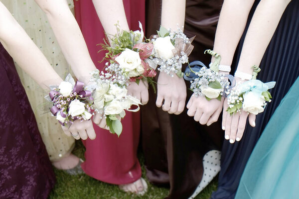 Девушки, держащие в руках букетики цветов для выпускного вечера
