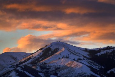 Vista of sunset light on mountains or sunrise with golden and pink hues with radio towers communication