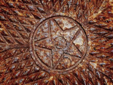 Metal bir rögar kapağında paslı yıldız tasarımı ayrıntıları