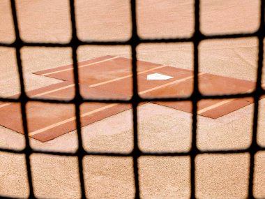 Baseball practice area fence with home plate for warm up pitching clipart