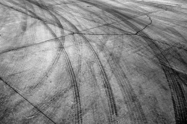 Black tire tracks or marks from driving on cement drive