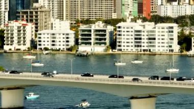 Telephoto aerial video traffic on Sarasota causeway with buildings in background