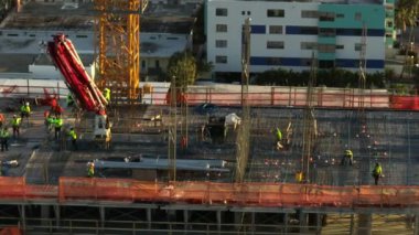 Aerial video construction site crew working overtime at sunset