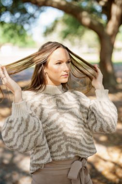 Saçını düzelten güzel bir genç kadının fotoğrafı.