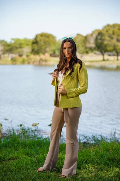 公園で見られる性質の緑のジャケットに身を包んだ美しい若い女性モデル — ストック写真