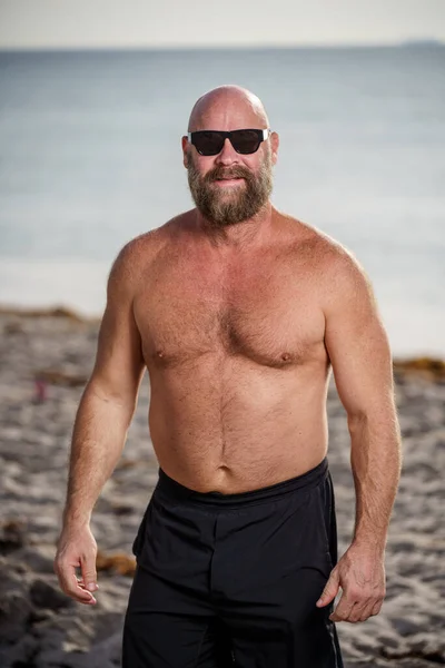 Tough man with beard on the beach