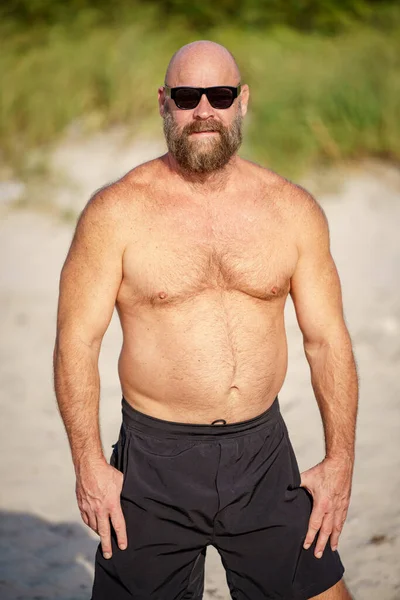 Sahilde Güneş Gözlüklü Kaslı Sakallı Bir Adamın Fotoğrafı — Stok fotoğraf