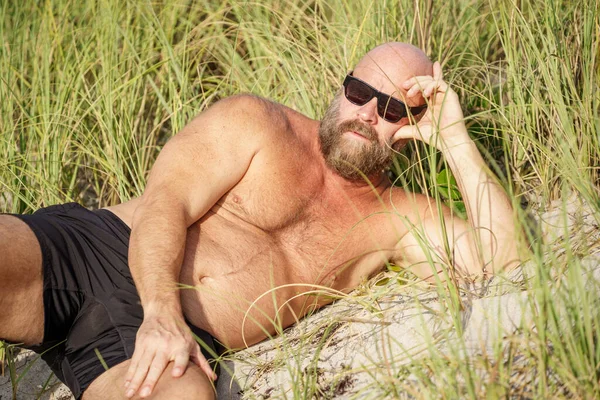海滩沙丘上的秃头男子 — 图库照片