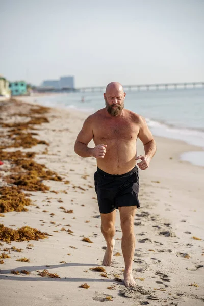 在海滩上奔跑的硬汉白人 — 图库照片