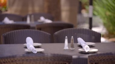 Restoran masası tuz biberi ve gümüş takımları peçetelere sarmış. 4k 24 peni arkaplanı bokeh bulanık olan işyerleri