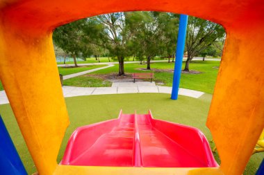 Childs pov oyun parkındaki kaydırağın altına bakıyor.