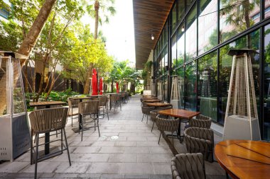 Şehirdeki bir geçitte restoran masaları.