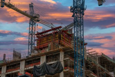 Vinçler inşaat sahasında gün batımında gökyüzü fotoğrafı