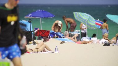 Fort Lauderdale, FL, ABD - 23 Mart 2024: plajda bronzlaşan genç bir kadın. HDR 4k video Fort Lauderdale 2024 Bahar Tatili