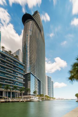 Miami ve Brickell 'i araştır. Yüksek kulelerle kaplı Miami Nehri manzarası. Gökyüzünde ve suda hareket bulanıklığı ile uzun pozlama