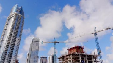 Miami şehir merkezinde gökdelenler ve vinçler. 4k hava aracı videosu yukarı doğru eğik.