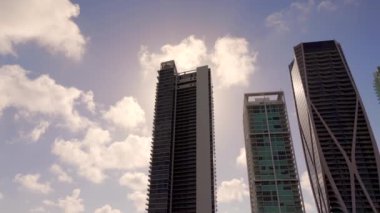 Miami şehir merkezindeki yavaş çekim yapan yüksek kuleler. Binaların ve yuvarlanan bulutların görüntüsü