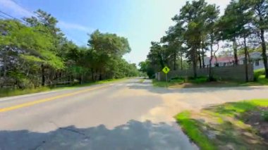 Marthas Vineyard, MA, ABD - 15 Temmuz 2024: Marthas Vineyard Adası Massachusetts 2024 'te gölgeli kaldırımlarda bisiklet sürmek