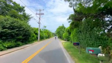 Marthas Vineyard, MA, ABD - 15 Temmuz 2024: Marthas Vineyard 'da bisiklet süren bir adamı takip etmek