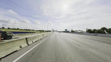 4K plakalı, parlak güneşli otoyolda araba sürüyorum.