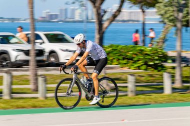 Key Biscayne Miami, FL, ABD - 8 Mart 2025: Miami 'de bisiklet süren yavaş panjurlu genç adamlar