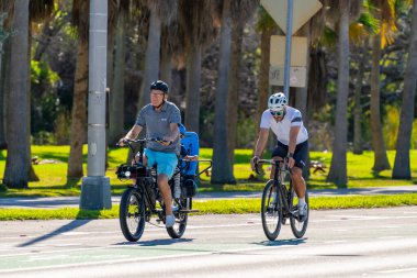 Key Biscayne Miami, FL, ABD - 8 Mart 2025: Çok nesilli, büyükbaba ve oğul Miami, Florida 'da bisiklet sürüyor