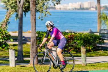 Key Biscayne Miami, FL, ABD - 8 Mart 2025 Key Biscayne Miami, Florida 'da bisiklet süren güzel genç kadın