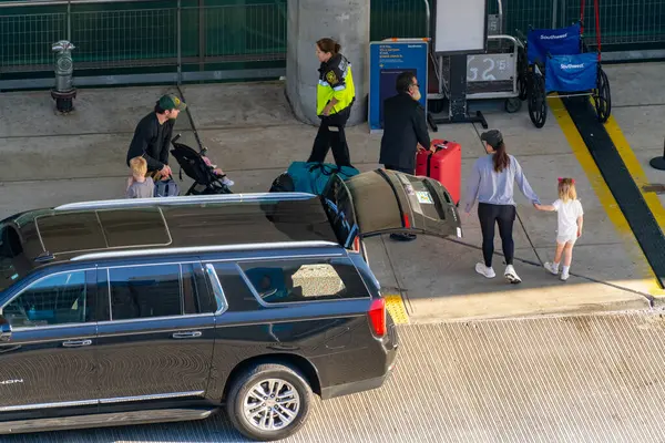 Fort Lauderdale, FL, ABD - 13 Mart 2025: Aile havaalanına geliyor ve bagajlı araçtan iniyor