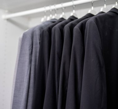 Dolaba asılmış düzgün renk sıralı iş gömlekleri.